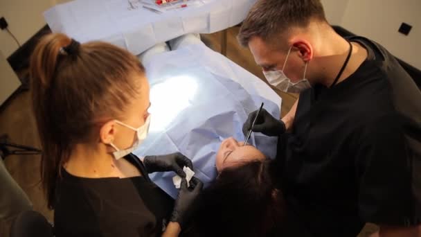 一位外科医生在进行抗衰老手术之前 对眼睛周围的皮肤进行检查 该妇女由一名专业整形外科医生提供咨询 — 图库视频影像