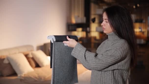 Beautiful Long Haired Brunette Carefully Examines Catalog Furniture Fabrics Furniture — Stock Video