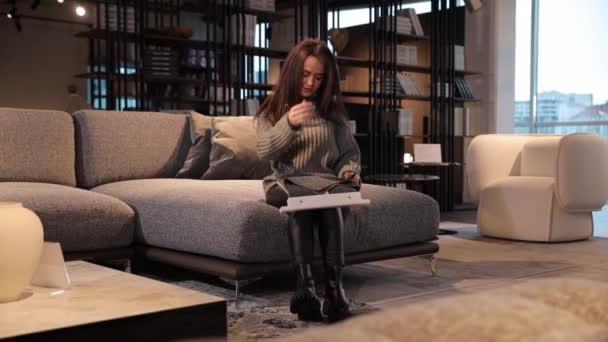 Beautiful Long Haired Concentrated Woman Sitting Sofa Furniture Showroom Looking — Stock Video