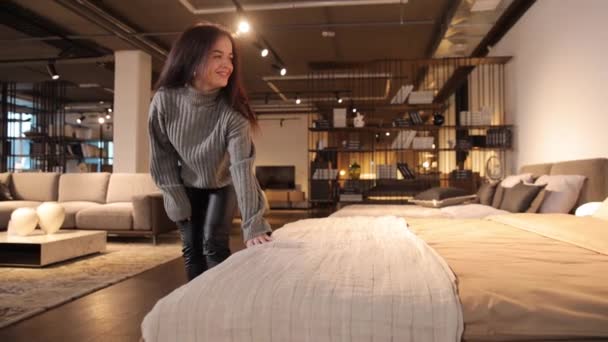迷人而积极的女人选择柔软的家具作为新房 触摸沙发 在现代家具超级市场里有许多舒适的家具可供选择 卫生间的家具 — 图库视频影像