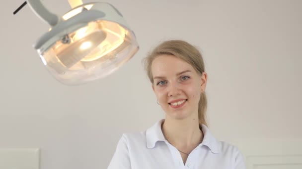 Retrato Una Joven Dentista Positiva Sobre Fondo Blanco Cerca Lámpara — Vídeos de Stock