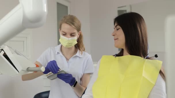 歯科治療のために準備するポジティブな若い女性患者と歯科医 近代的な方法による歯科疾患の治療 — ストック動画
