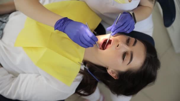 클리닉에서 약속하는 치아를 치료하는 기구를 사용하여 장갑을 착용하는 의사의 비디오 — 비디오