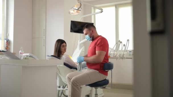 Ένας Οδοντίατρος Ιατρική Μάσκα Συζητά Ένα Σχέδιο Θεραπείας Έναν Ασθενή — Αρχείο Βίντεο