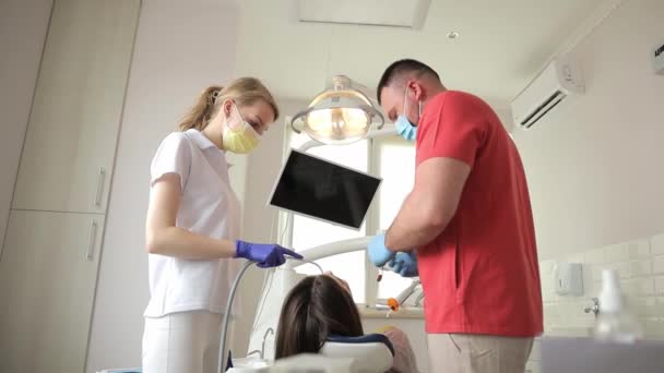 女性の歯の治療中に医師と歯科医のアシスタント 現代歯科オフィスでの歯科治療のプロセス 歯科疾患のタイムリーな検出 — ストック動画