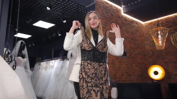 Die Attraktive Schlanke Blondine Wählt Ein Abendkleid Einer Brautboutique Auswahl — Stockvideo