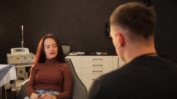 Una Mujer Está Sentada Una Silla Dental Compartiendo Una Conversación — Vídeo de stock