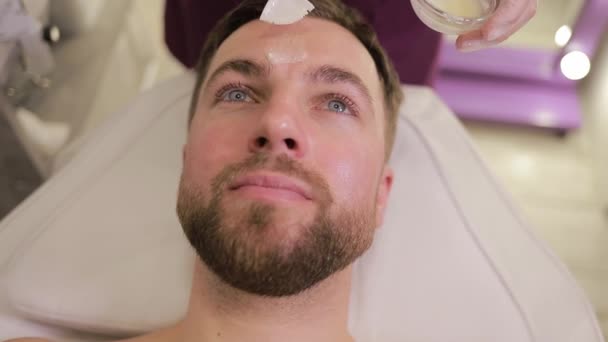 Man Med Skägg Får Ansiktsbehandling Ett Spa Med Fokus Panna — Stockvideo