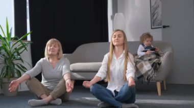 İki kadın boş boş boş yerde gözleri kapalı bir şekilde oturuyorlar. Etkinlikte rahatlama ve eğlenme anlarını paylaşıyorlar.