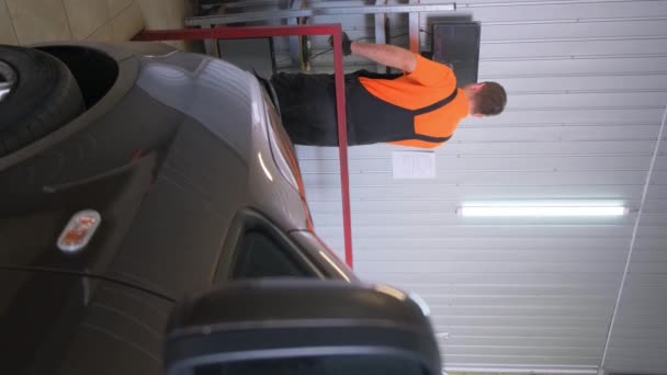 Mężczyzna Stoi Obok Produktu Motoryzacyjnego Pojazdu Oponami Samochodowymi Oświetleniem Garażu — Wideo stockowe