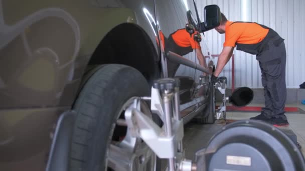 Twee Personen Repareren Van Een Voertuig Een Garage Gericht Autoband — Stockvideo