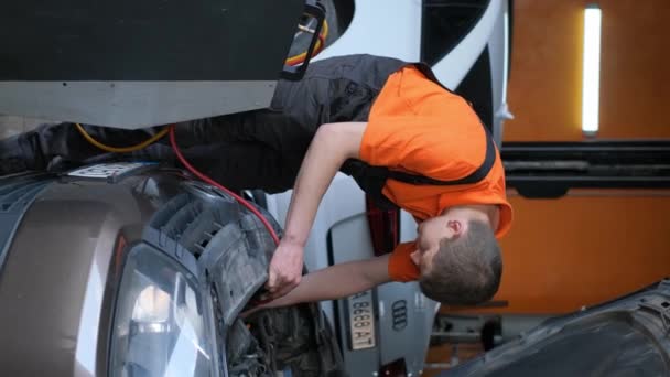 Mężczyzna Naprawia Maskę Samochodu Garażu Pracując Nad Elementami Zewnętrznymi Takimi — Wideo stockowe