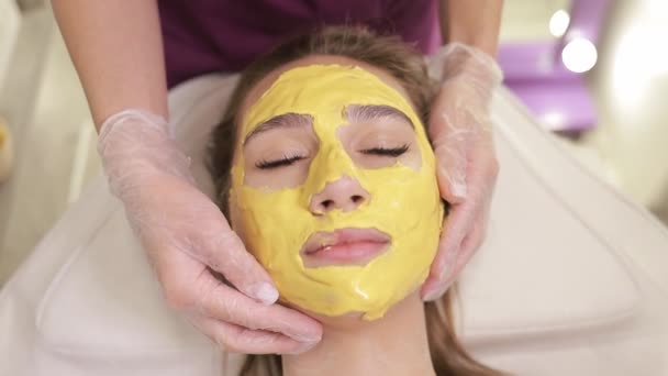Wanita Itu Mengenakan Masker Wajah Kuning Diterapkan Pada Kulitnya Spa — Stok Video
