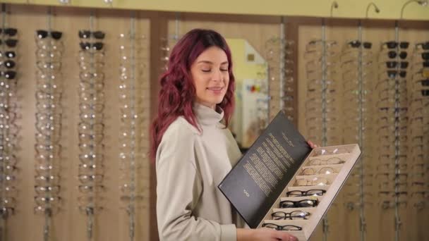 Joven Chica Rizada Linda Satisfecha Sosteniendo Una Caja Con Gafas — Vídeos de Stock