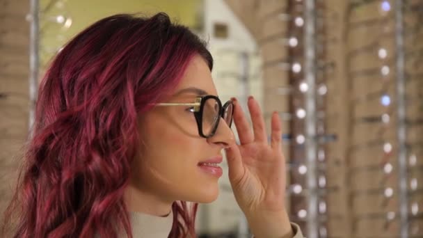 Chica Elige Gafas Con Monturas Oscuras Posa Frente Espejo Mira — Vídeos de Stock