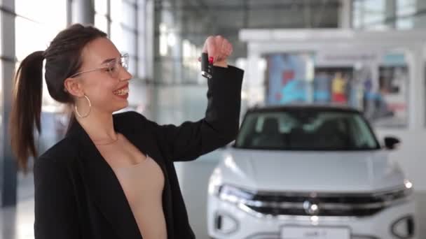 Een Vrouw Staat Voor Een Witte Auto Met Een Autosleutel — Stockvideo
