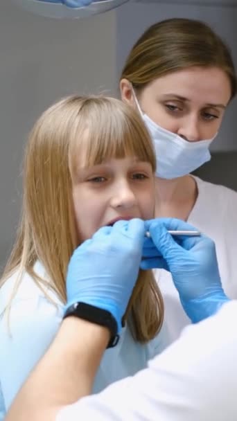 소녀는 그녀의 손가락으로 그녀의 머리와 피지와 그녀의 의사에 그녀의 치아를가지고 — 비디오
