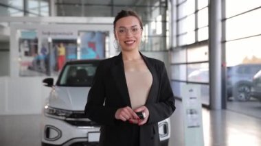 Bir kadın galeride kapüşonlu ve yansıtıcı aynalı araçların önünde duran bir arabanın otomotiv tasarımına hayran.