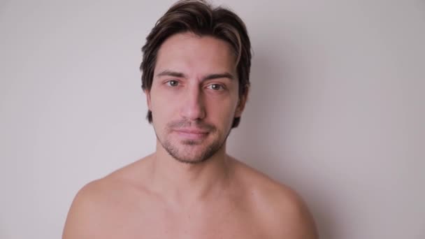 裸の胸を持つひげ付きの男は 彼の額 まつげ および全体的な人間の体を展示し カメラと目を合わせています — ストック動画