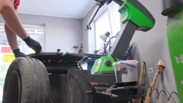 一个人站在车库里的一个汽车轮胎上 看着合成橡胶轮系的脚步声 这是汽车的一个重要组成部分 — 图库视频影像