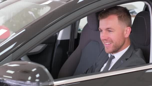 Szczęśliwy Uśmiechnięty Mężczyzna Garniturze Biznesowym Siedzi Nowym Samochodzie Jazda Próbna — Wideo stockowe