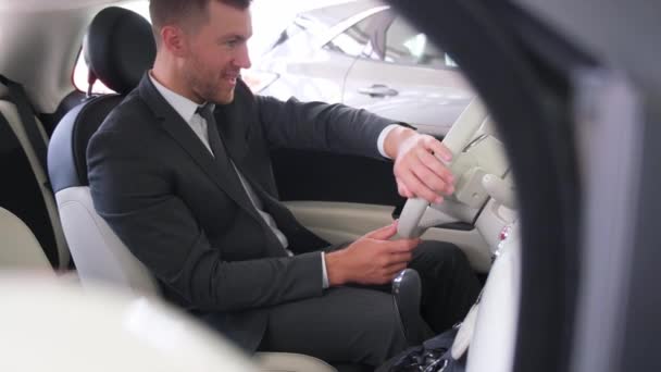 車を購入する前にテストドライブを取る新しい車の車輪の後ろに座っている満足したヨーロッパの男性 ビジネスマンが新しい車を買う — ストック動画