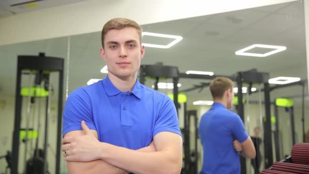 Homem Com Uma Camisa Azul Elétrica Está Ginásio Seus Braços — Vídeo de Stock
