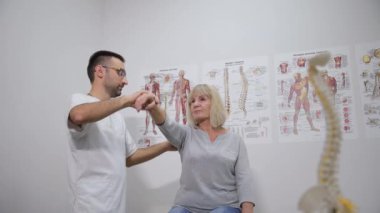 Nazik dokunuşunu kullanarak, adam güçlü parmağıyla kolunu destekleyerek yaşlı kadına yardım teklif etti. İçten bir nezaket göstergesiydi.