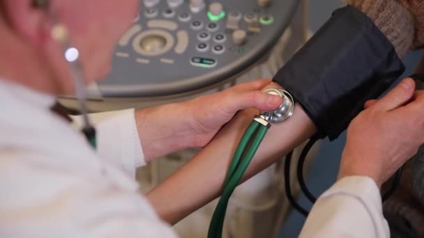 家族の医者と約束した少女 高齢の医師は 血圧をステートスコープで測定する ユースヘルスケア — ストック動画