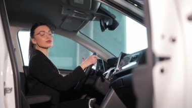 Başarılı bir iş kadını yeni bir arabanın içinde oturuyor ve kameraya bakıyor. Bir kadın test sürüşü yapar. Araba itme.