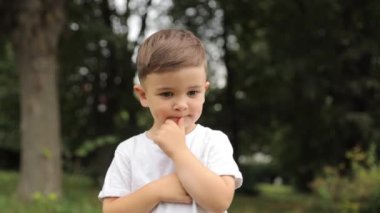 Küçük çocuk parkta ellerini çırpıyor..