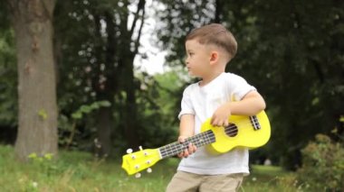 Güzel çocuk gitar ya da gitar çalar. Yüksek kalite 4k görüntü