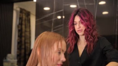 Güzel bir kadın kuaför bir güzellik salonunda sarı saç kesiyor. Kadın tıraşı. Yüksek kalite 4k görüntü