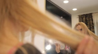 Genç sarışın kadın aynadaki yeni saç stiline hayran. Yüksek kalite 4k görüntü