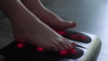 Bir insan ayak masajı aletini rahatlatıcı ve rahatlatıcı bir masaj için kullanır. Yakından bakıldığında kendine bakmanın keyfini çıkarır.