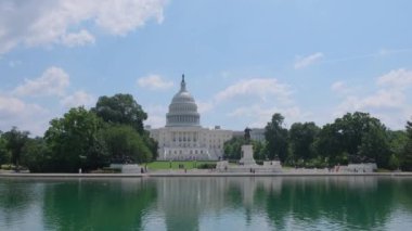 Washington Anıtı 'nın yakınındaki sularda yansıtılan Capitol Binası' nın sakin bir görüntüsü Washington 'un simgelerini ve tarihlerini gözler önüne seriyor.