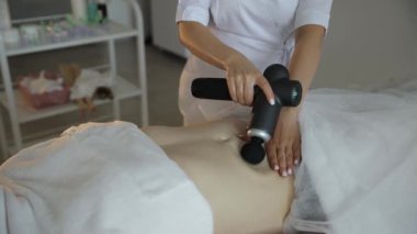 Huzurlu bir kaplıcada, bir kadın erkeğe rahatlatıcı bir masaj yapar, ona rahatlatıcı ve tedavi edici bir atmosfer yaratır.