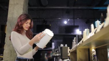 Elektronik mağazasının önünde duran kadın almadan önce çaydanlığı seçiyor. Yüksek kalite 4k görüntü