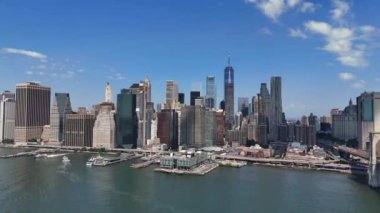 Geniş bir hava manzarası simgesel New York şehrinin ufuk çizgisini ön planda zarifçe uzanan huzurlu bir su kütlesiyle tamamlıyor.