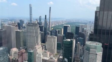 Güneşli bir günde New York 'un gökyüzü ve Central Park manzarasının tadını çıkarın. Bu video önemli işaretleri ve şehrin canlı atmosferini yakalar.
