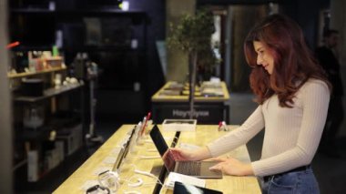 Perakende satış yapan bir kadın, modern tüketici davranışlarını ve teknolojinin günlük hayata entegrasyonunu gösteren bir dizüstü bilgisayar ve tablet kullanıyor.