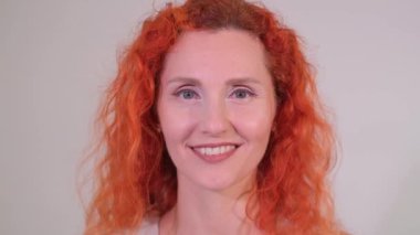 Bu canlı video, neşeli, kızıl saçlı, neşeli, gözleri kapalı, neşeli yüzlü ve parlak bakışlı bir kadını gösteriyor.