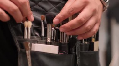 Videoda güzellik meraklısı biri makyaj aletlerini düzenliyor ve hazırlıyor. Güzellik maceraları için şık bir çantada canlı fırçalar bulunuyor.