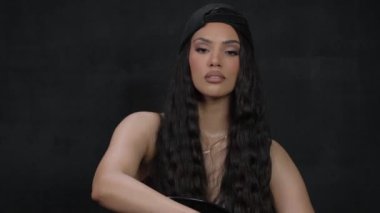 Bu video, yolculuğunda uzun siyah saçlı bir kadını takip ediyor. Kendine güveni tam olarak yerine geliyor ve saçını cesurca kesiyor. Değişimi sembolize ediyor.