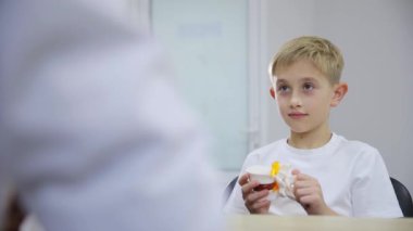 Bu ilgi çekici videoda, genç bir çocuk çeşitli nesneleri keşfediyor, önce bir hap şişesi, sonra bir iskelet modeli, ve son olarak da bir oyuncak, merak ve öğrenme dengeleyici