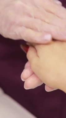 Bir kadın kaplıcada rahatlatıcı bir el masajı yaptırıyor, parmaklarına, baş parmağına, bileğine ve tırnaklarına odaklanıyor. Terapist ellerine nazik jestler yapar. Gerginliği azaltır ve rahatlamasını sağlar.