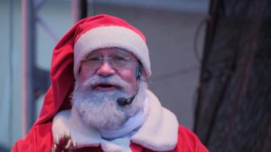 Olumlu yaşlı bir Amerikan Noel Baba sahnede dururken seyircilere mikrofona konuşur. Noel Baba insanlara mutlu Noeller diler, duygusal jestler yapar. Yeni yıl partisi.