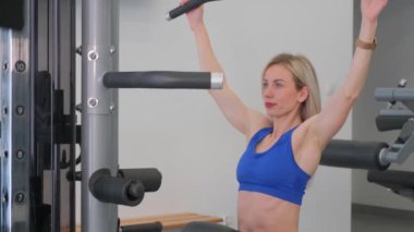 Genç bir kız spor salonunda antrenman yapıyor. Kuvvet eğitimi.