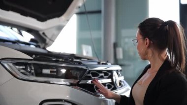 Kaputu açık, araba galerisi olan bir kadın. Yüksek kalite 4k görüntü