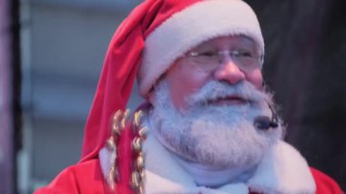 Olumlu yaşlı bir Amerikan Noel Baba sahnede dururken seyircilere mikrofona konuşur. Noel Baba insanlara mutlu Noeller diler, duygusal jestler yapar. Yeni yıl partisi.